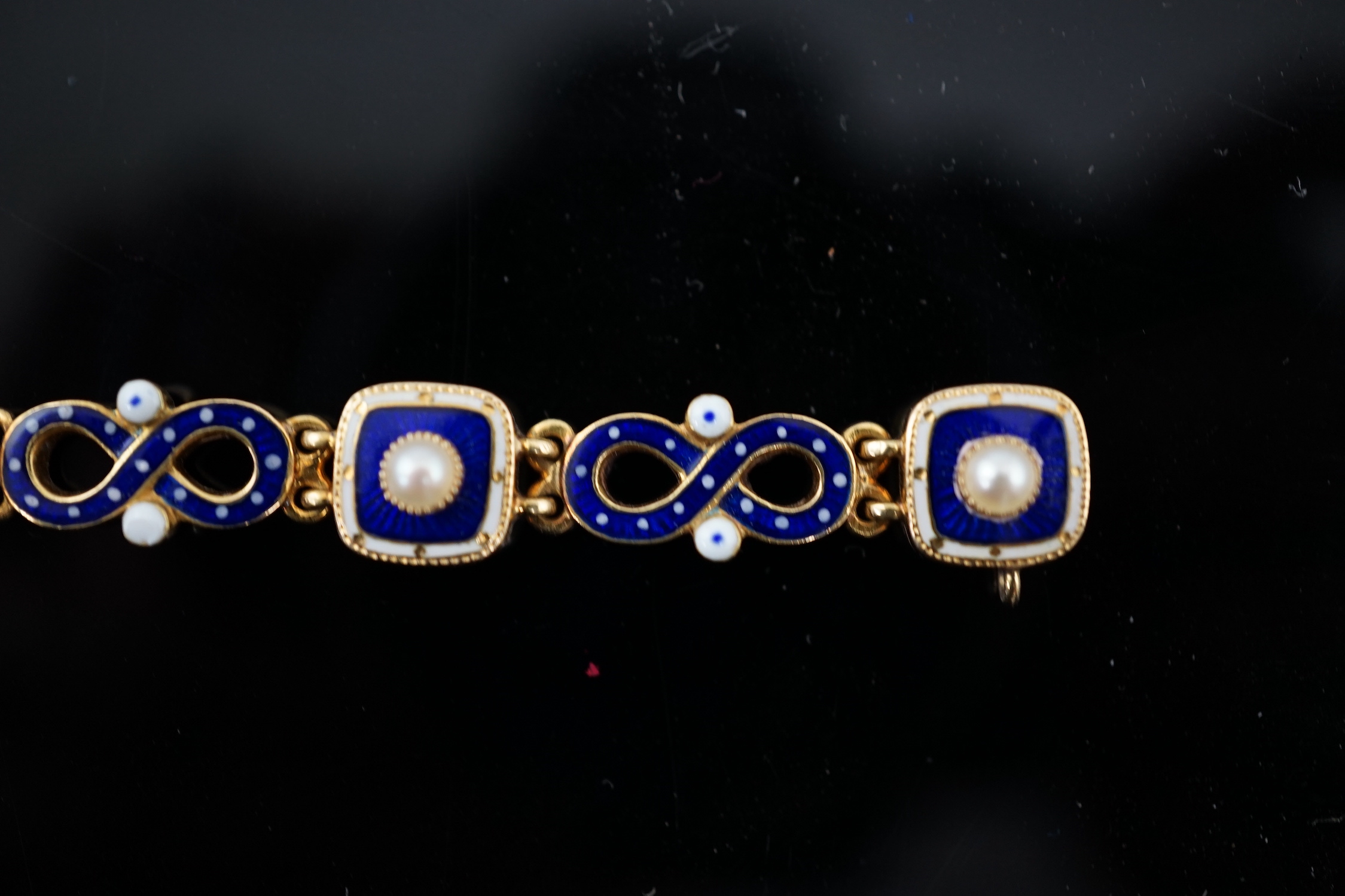 An early 20th century gold (tests as 18ct), two colour enamel and spilt pearl set bracelet
